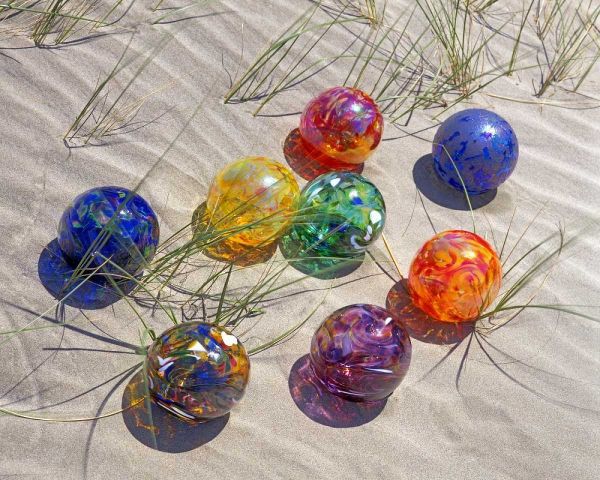 USA, Oregon Colorful glass floats on sand dune